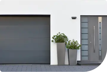 Gray modern style garage door with planters along side